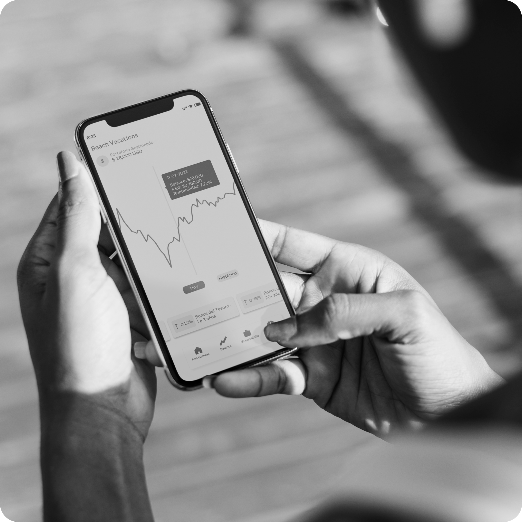 Imagen en blanco y negro de dos manos que sostienen un celular inteligente. Se ve la interfaz de la App Insights